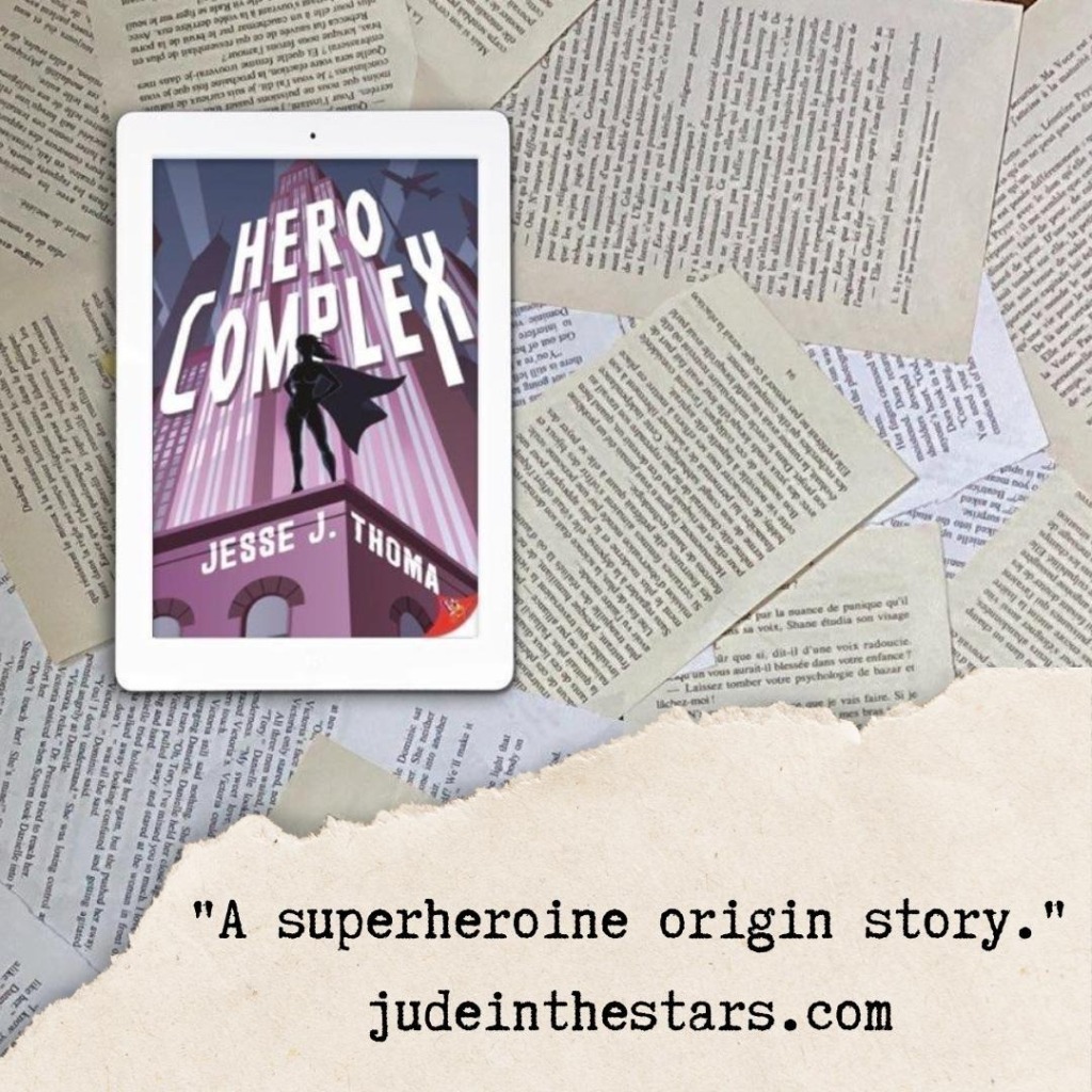On a backdrop of book pages, an iPad with the cover of Hero Complex by Jesse J. Thoma. At the bottom of the image, a strip of torn paper with a quote: "A super heroine origin story." and a URL: judeinthestars.com.